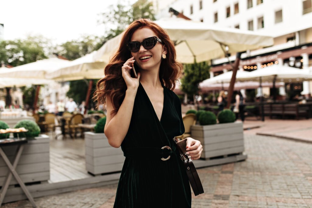 lady in velvet dress talking on phone outside